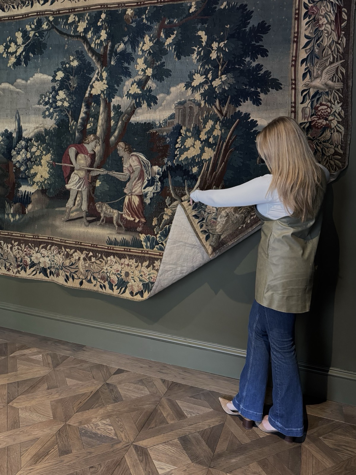 Examining the detail of an antique tapestry